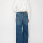 Woman wearing a white blouse and blue jeans on a white background